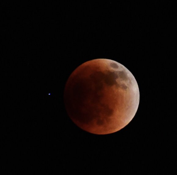 A red moon is shown in the sky.