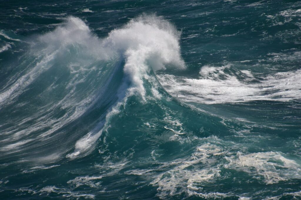 A large wave is crashing in the ocean.