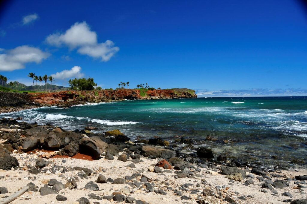 A beach with rocks and water near the shore.