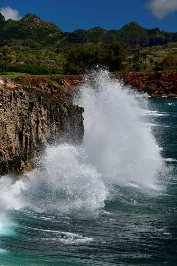 A wave crashing on the side of a cliff.