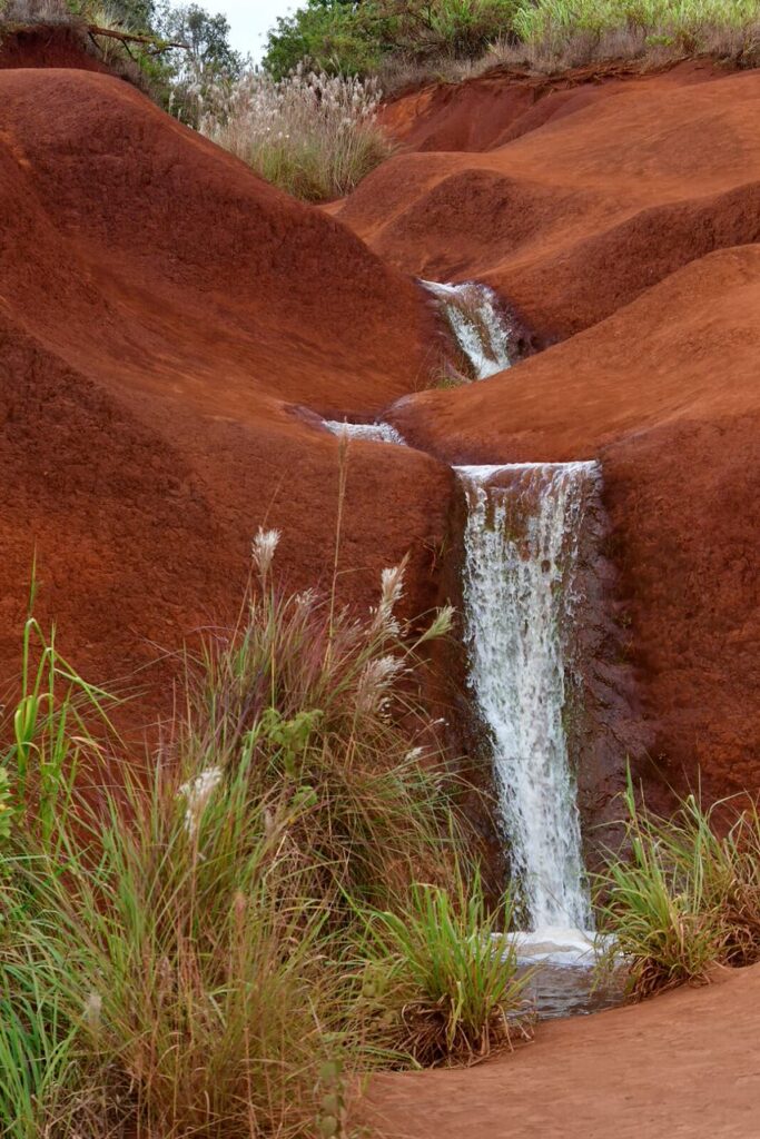 A waterfall in the middle of a red mountain.